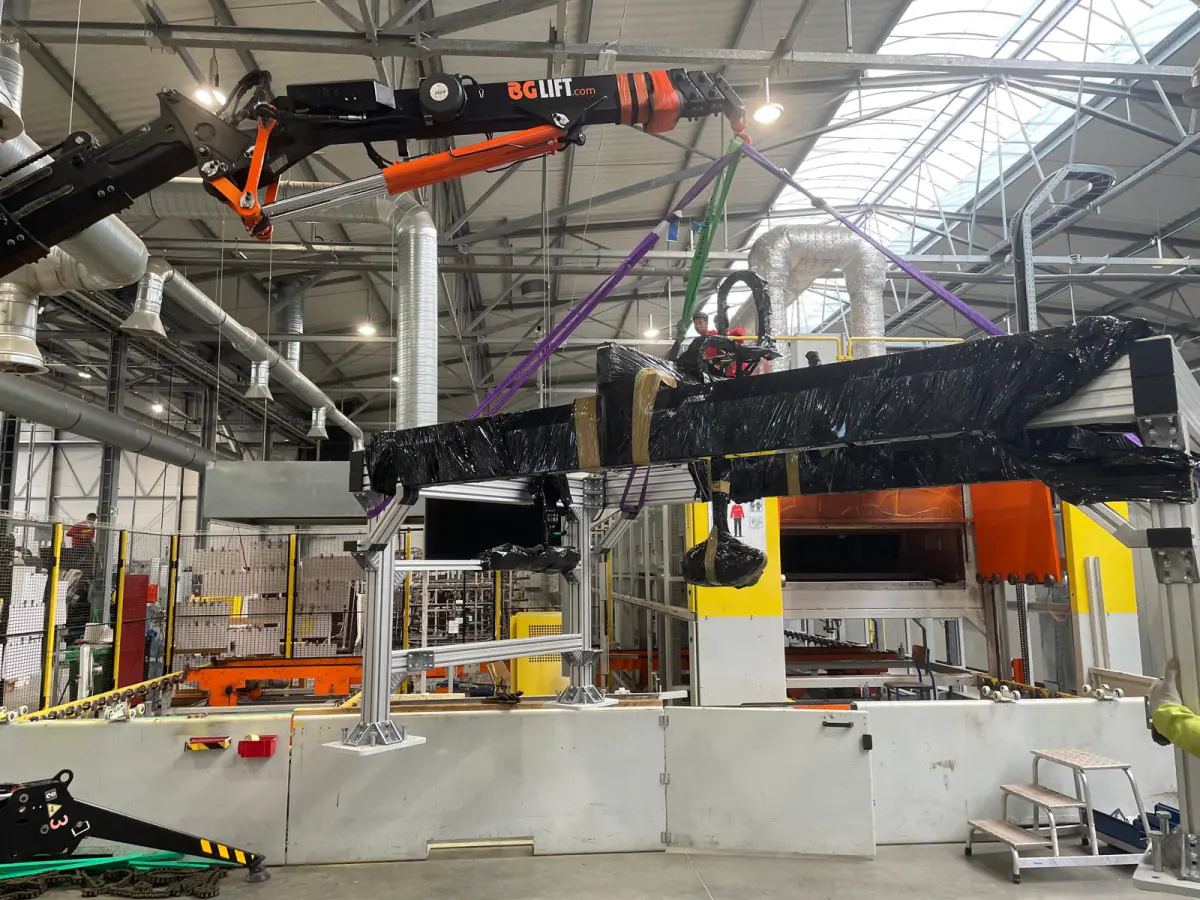 Mini żuraw BG Lift M250 przenosi owiniętą folią maszynę produkcyjną wewnątrz hali w Koszalinie