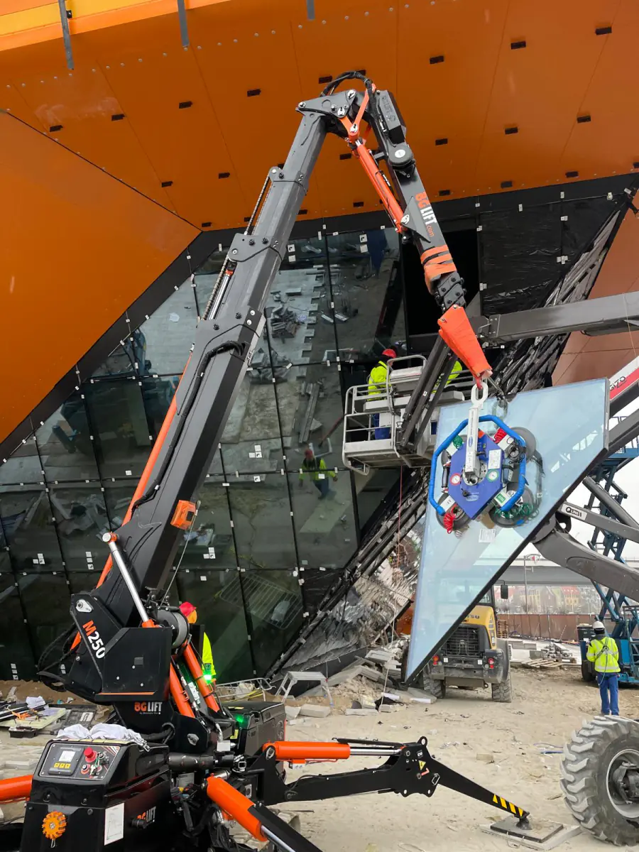 Mini żuraw JK Lift podnosi taflę szkła na przeszkloną fasadę budynku muzeum morskiego w Szczecinie