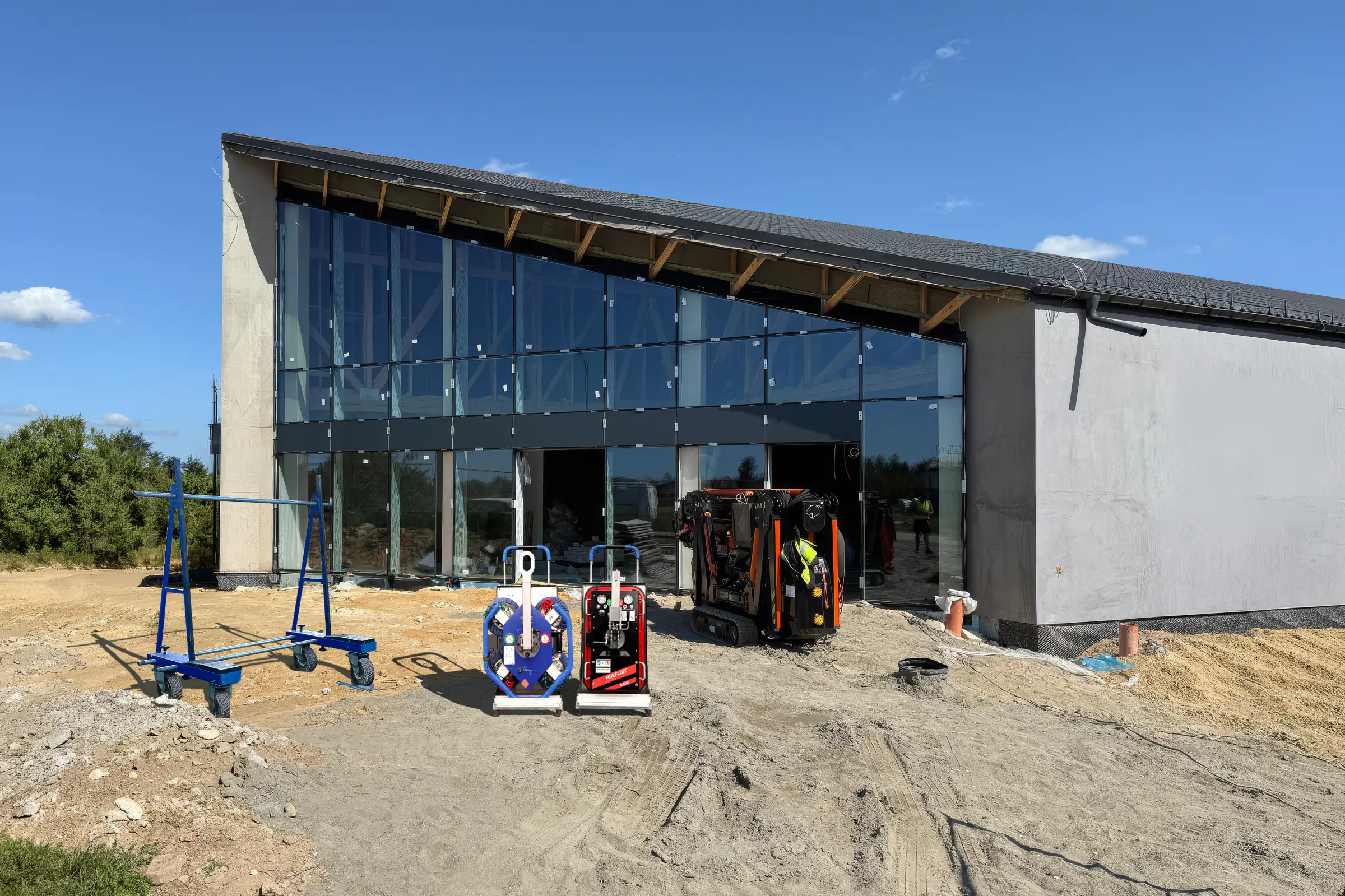 Sprzęt JK Lift na placu budowy: mini żuraw BG Lift M250, wózek transportowy GLW 800 i ssawka próżniowa VM Glass